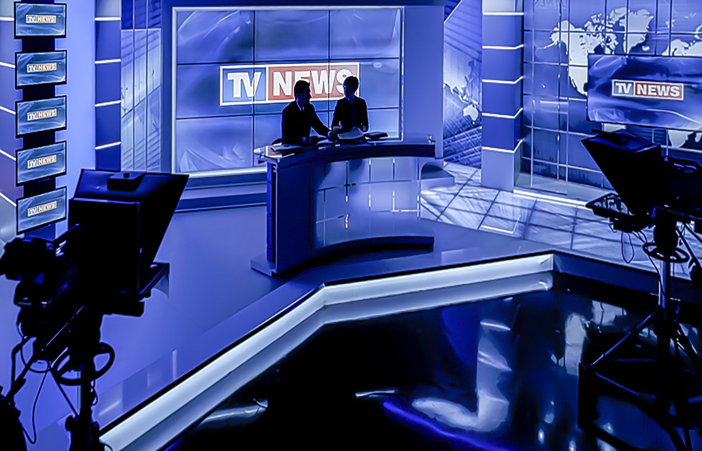TV news broadcast studio with anchors at desk, production cameras, and world map display
